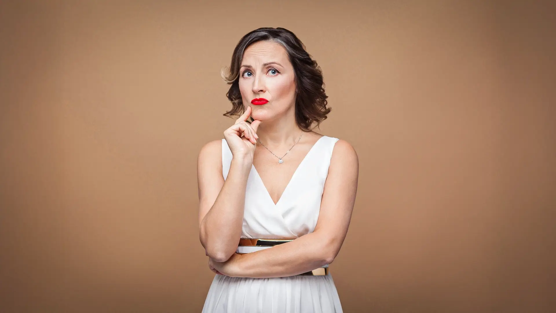 Woman appearing thoughtful, representing frequently asked questions – Paula Fortuna Beauty & Wellness, New Westminster BC