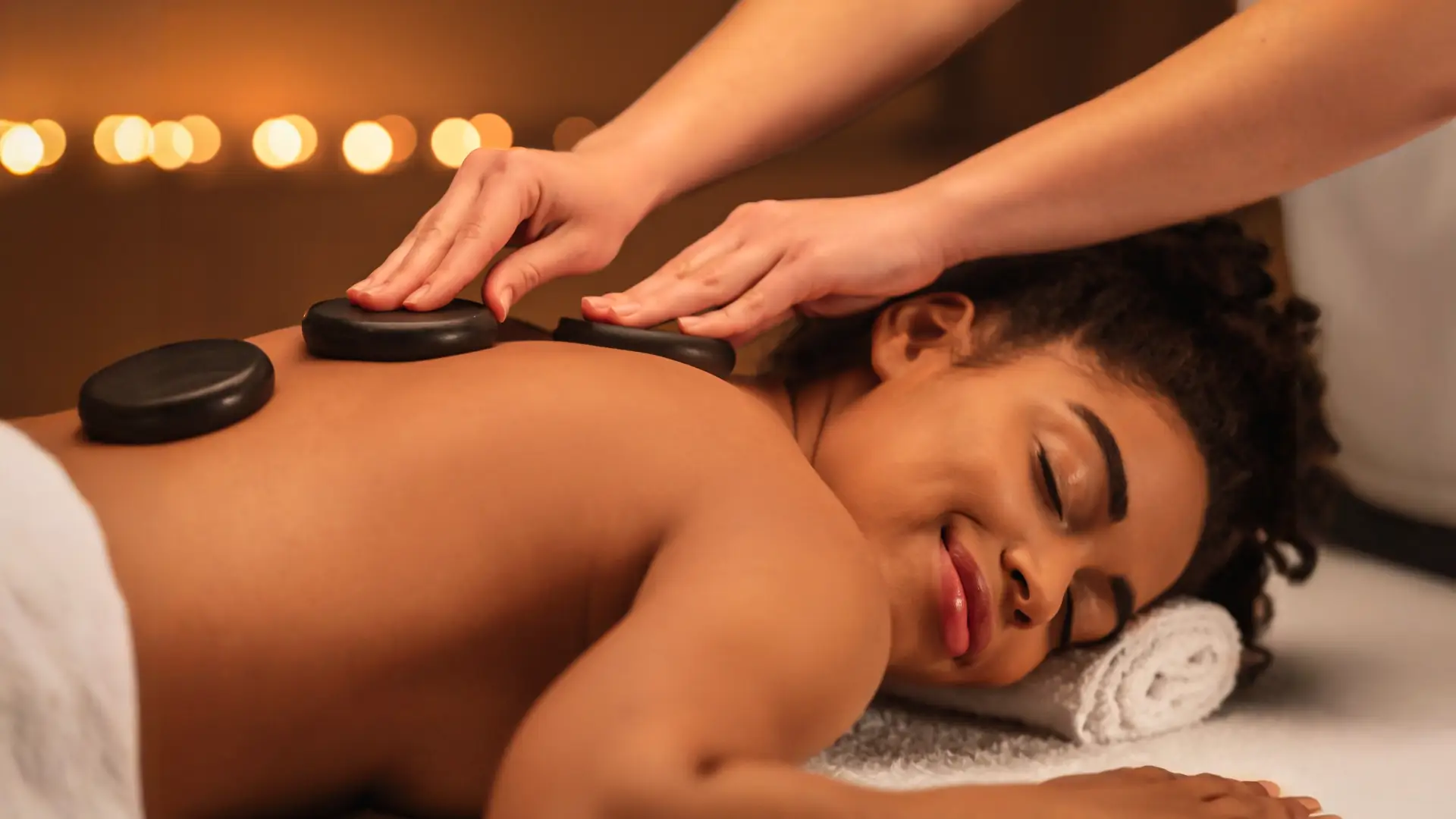 Hot stone massage therapy using heated basalt stones for deep relaxation – New Westminster spa service